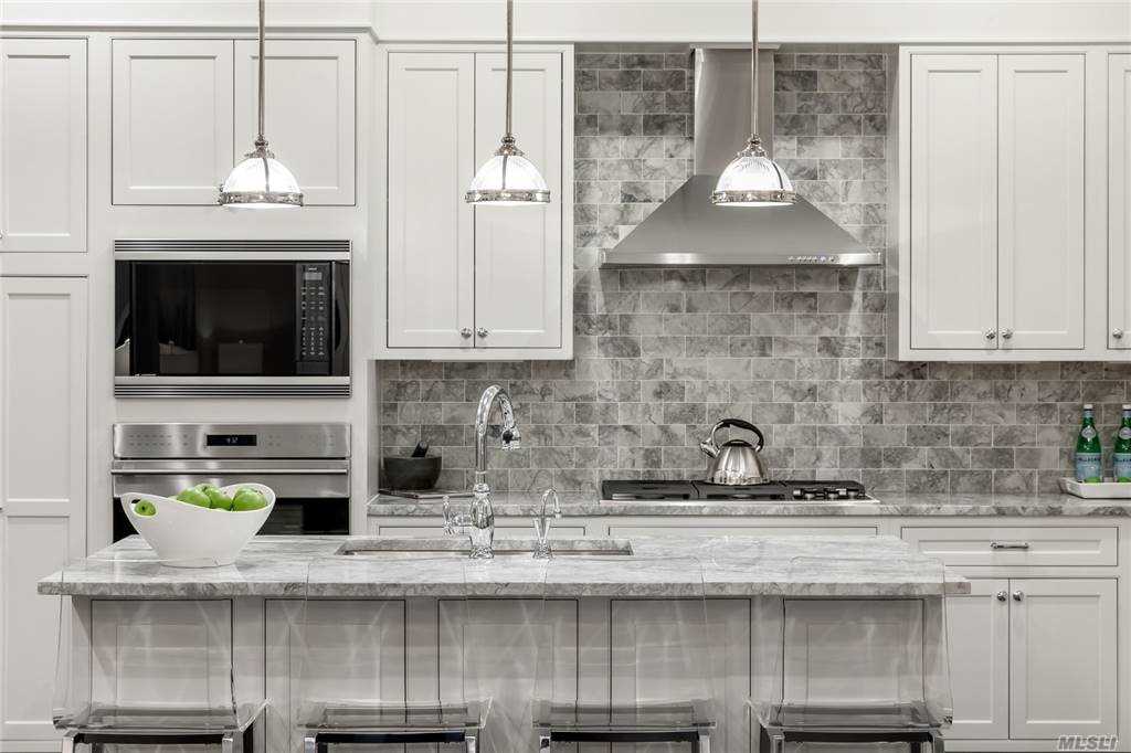a kitchen with stainless steel appliances granite countertop a sink and a white cabinets