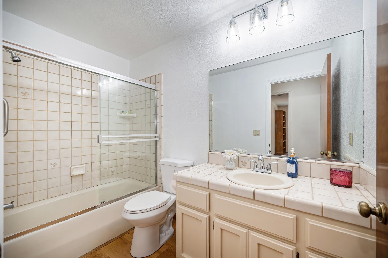 22803 Sunset Ridge Drive Auburn, CA 95602 - Photo 20 of 60 Guest Bathroom featues newly painted cabinets, new lighting, new luxury vinyl plank flooring and new toilet.