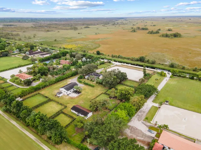 an aerial view of ocean and residential houses with outdoor space