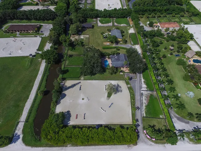 an aerial view of a house with a yard and lake view