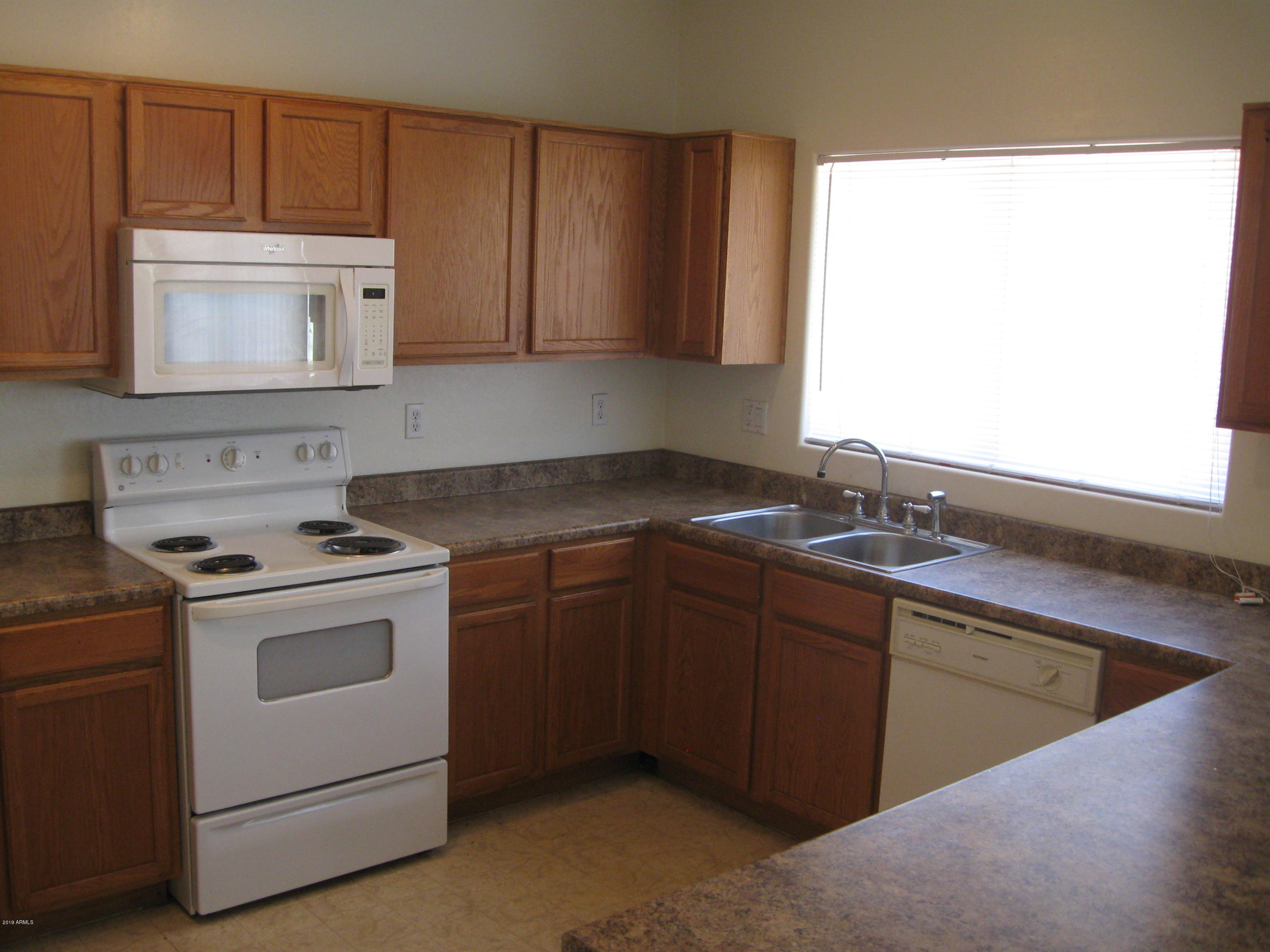 8746 West Heber Road Tolleson, AZ 85353 - Photo 7 of 36 a kitchen that has a sink and a stove