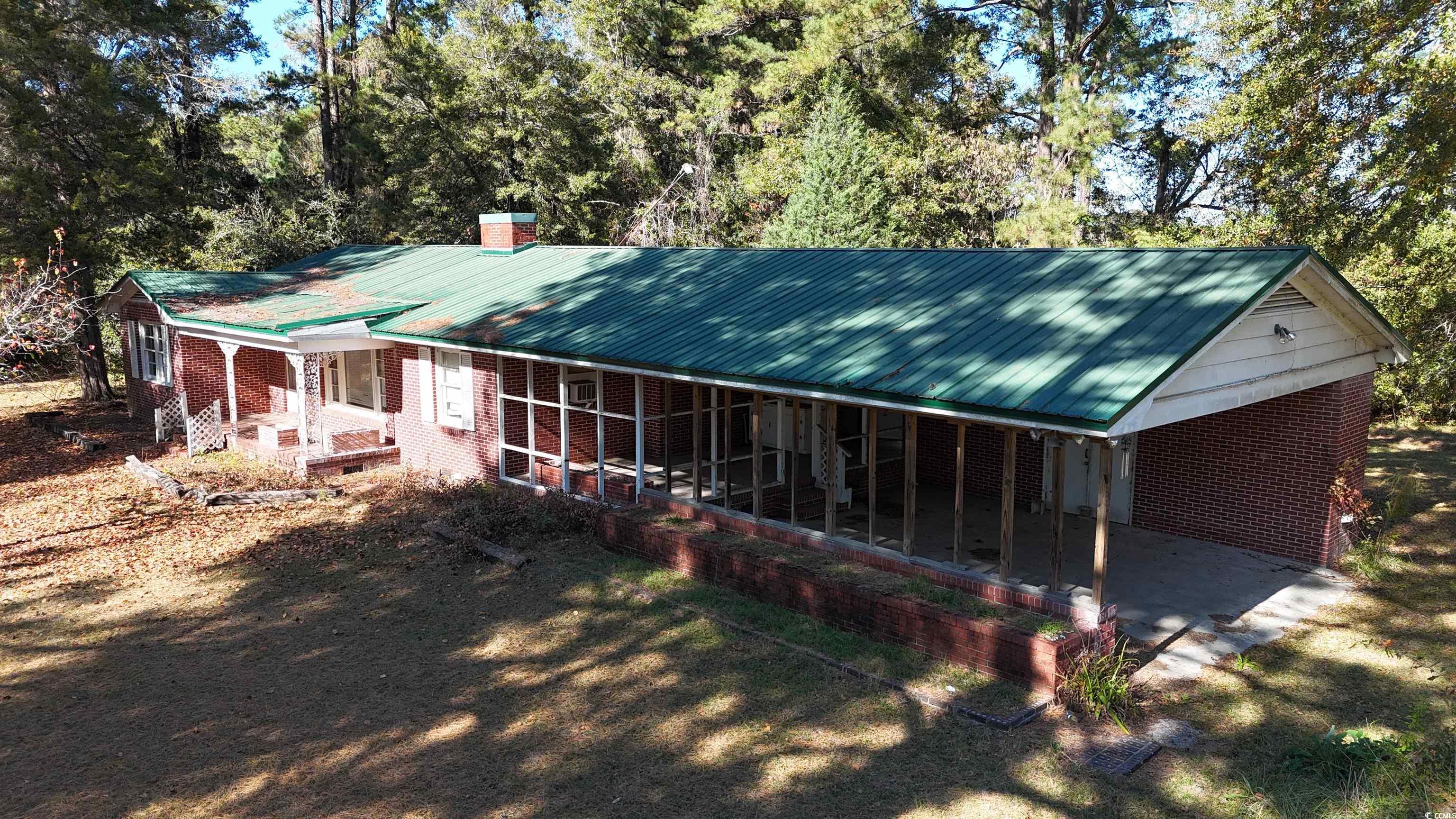 6800 State Rd S-26-266 Nichols, SC 29581 - Photo 18 of 20 View of front of house featuring a metal roof, a porch, brick siding, and a chimney