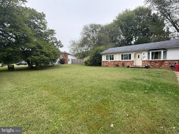 a view of a house with a yard and trees