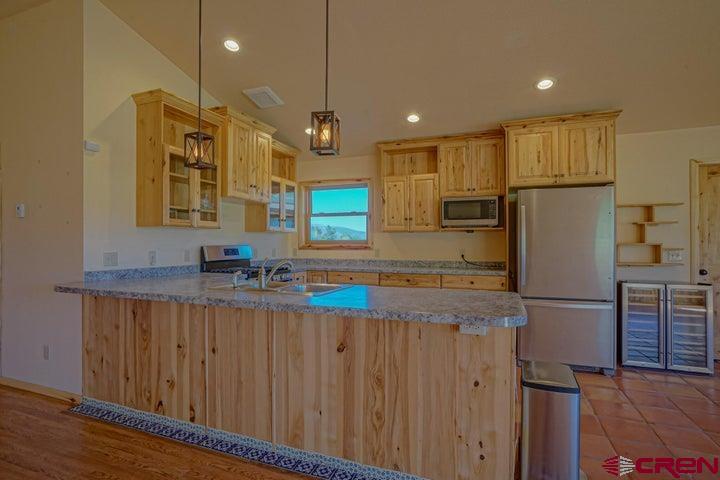 1810 Forbes Park Road Fort Garland, CO 81133 - Photo 20 of 25 a kitchen with stainless steel appliances granite countertop a refrigerator a sink and a stove