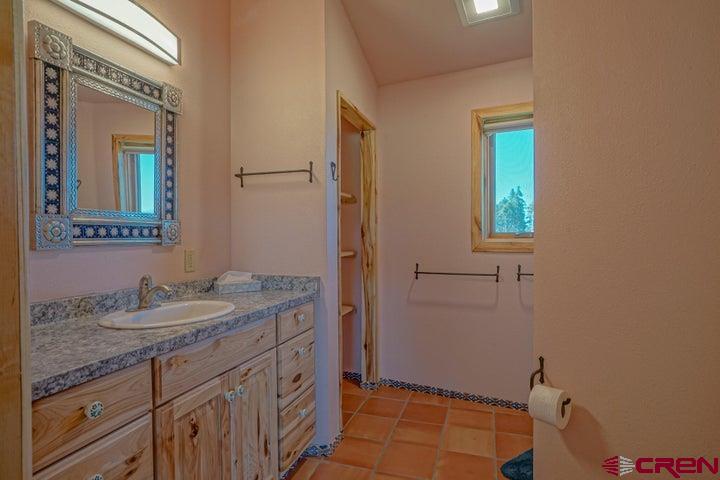 1810 Forbes Park Road Fort Garland, CO 81133 - Photo 2 of 25 a bathroom with a granite countertop sink a mirror and a toilet