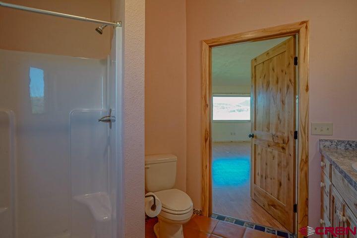 1810 Forbes Park Road Fort Garland, CO 81133 - Photo 3 of 25 a bathroom with a granite countertop toilet a sink and shower