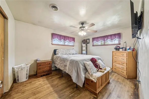 a spacious bedroom with a bed and wooden floor
