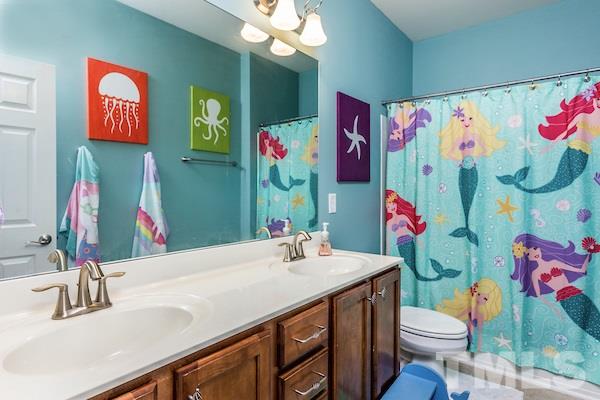 1144 Chapanoke Road Raleigh, NC 27603 - Photo 17 of 22 a bathroom with a sink vanity mirror and toilet