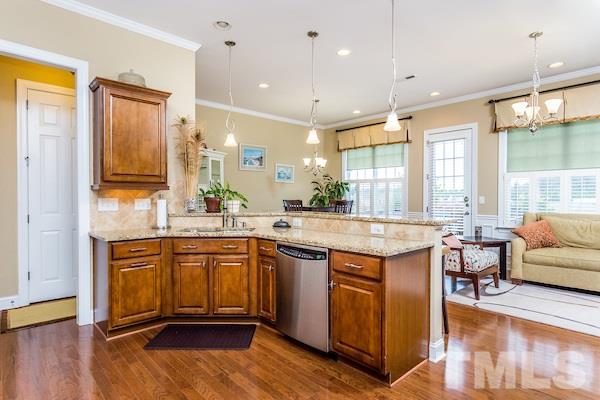 1144 Chapanoke Road Raleigh, NC 27603 - Photo 7 of 22 a kitchen with stainless steel appliances granite countertop wooden floors and view living room