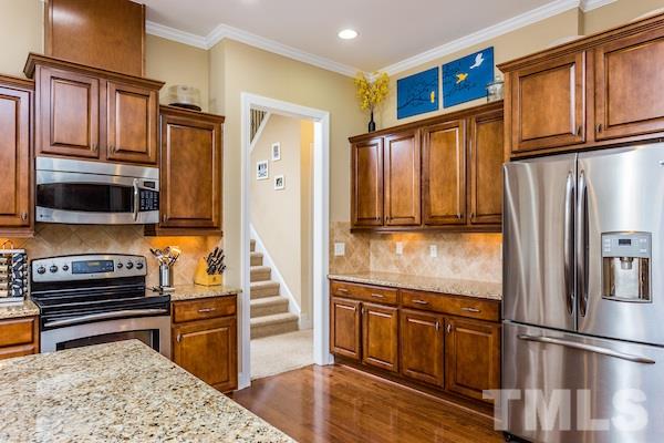 1144 Chapanoke Road Raleigh, NC 27603 - Photo 9 of 22 a kitchen with granite countertop a refrigerator and a stove top oven