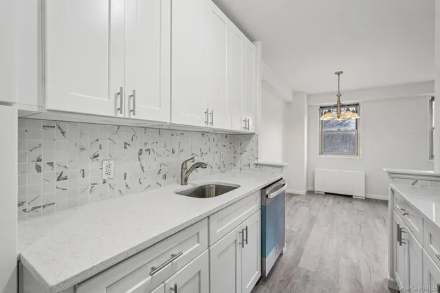 a kitchen with a sink and cabinets with wooden floor