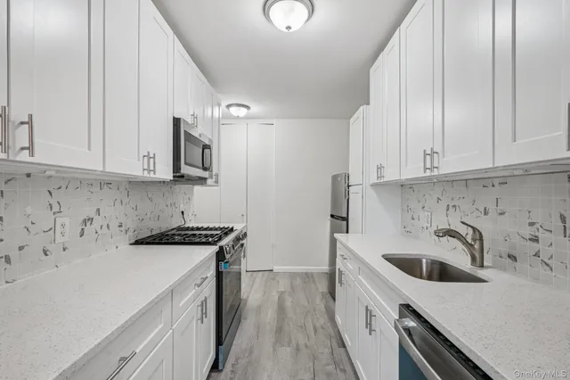 a kitchen with a sink a stove and cabinets
