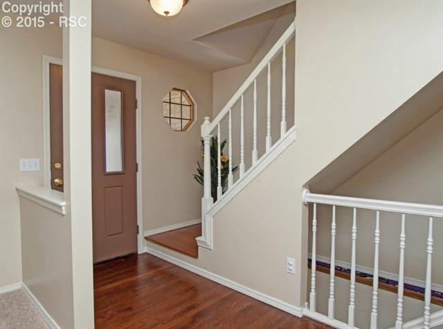 7831 Swiftrun Road Colorado Springs, CO 80920 - Photo 8 of 35 Light and bright front entry shows the newly finished floors that extend up the staircase