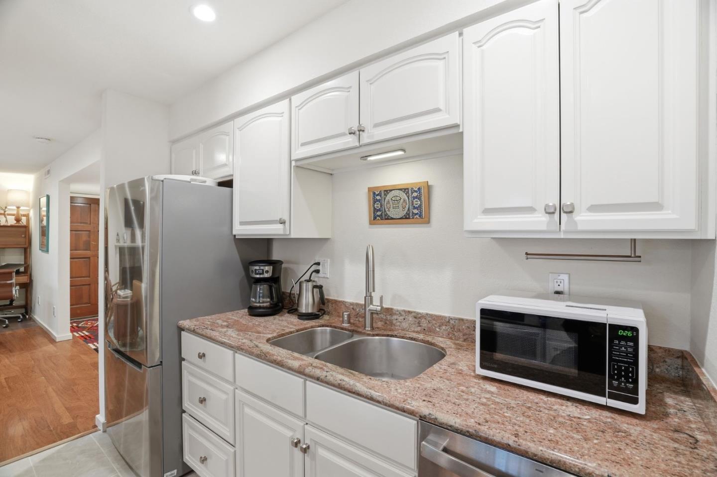 311 Bean Creek Road, Unit 301 Scotts Valley, CA 95066 - Photo 12 of 26 a kitchen with stainless steel appliances granite countertop a sink a refrigerator and a granite counter tops