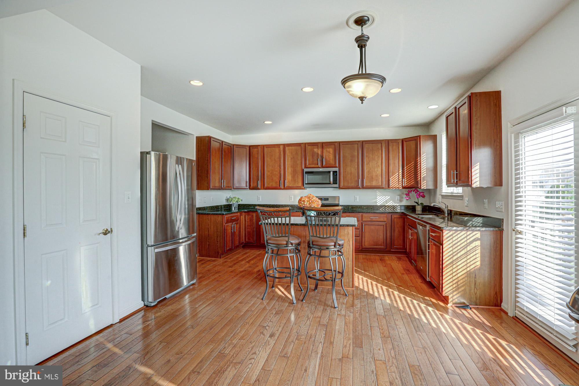 43 Autumn Terrace Magnolia, DE 19962 - Photo 42 of 86 a kitchen with stainless steel appliances a dining table chairs sink and wooden floor