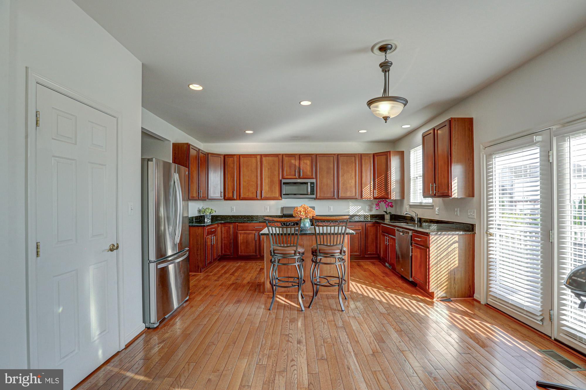 43 Autumn Terrace Magnolia, DE 19962 - Photo 43 of 86 a kitchen with stainless steel appliances granite countertop a refrigerator a sink dishwasher a stove and white countertops with wooden floor