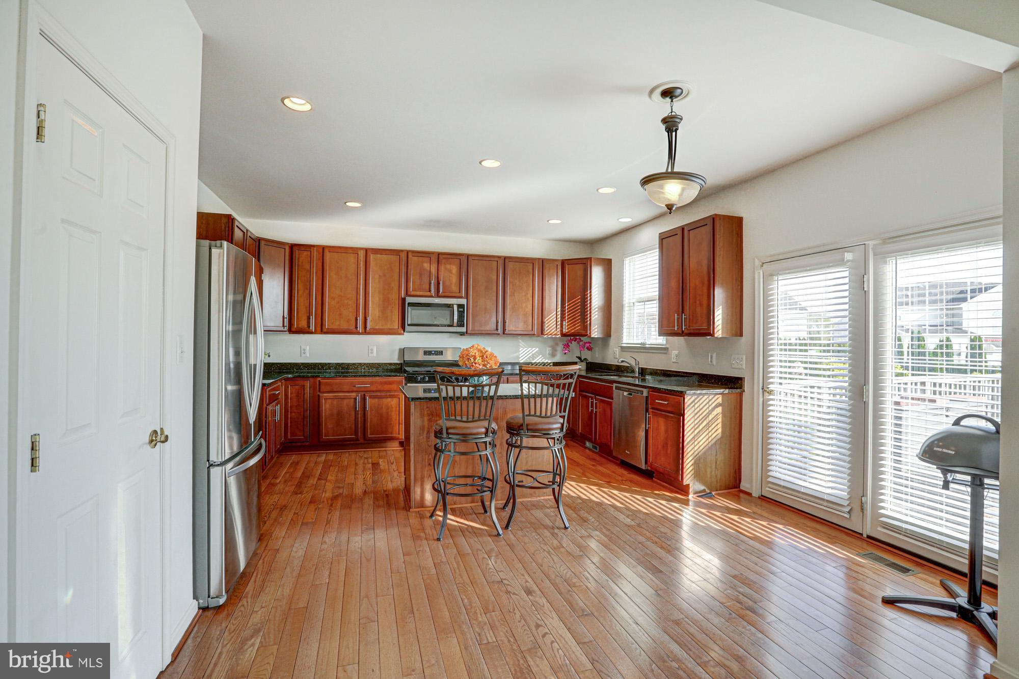 43 Autumn Terrace Magnolia, DE 19962 - Photo 44 of 86 a kitchen with stainless steel appliances kitchen island granite countertop wooden floors and a view of living room