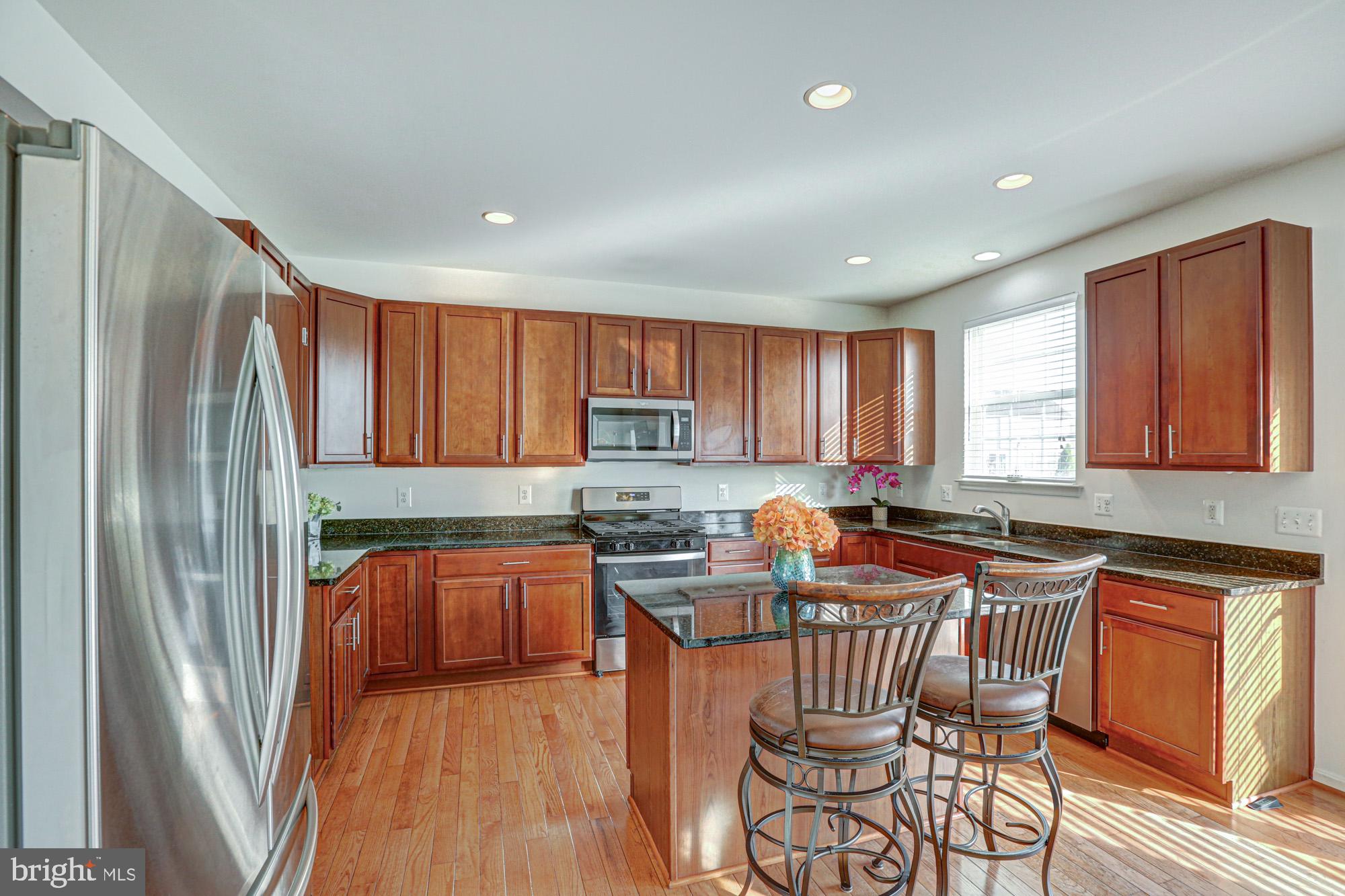 43 Autumn Terrace Magnolia, DE 19962 - Photo 45 of 86 a kitchen with stainless steel appliances granite countertop a refrigerator a sink dishwasher a stove and white countertops with wooden floor