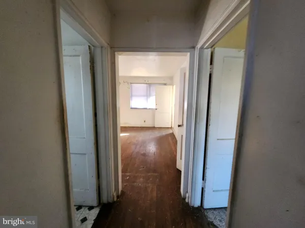 a view of a hallway with wooden floor and a door
