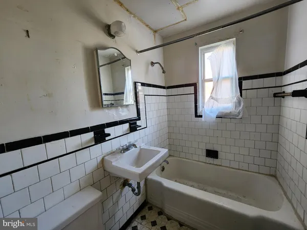 a bathroom with a bathtub sink and mirror