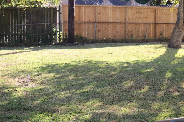 a view of a backyard with wooden fence