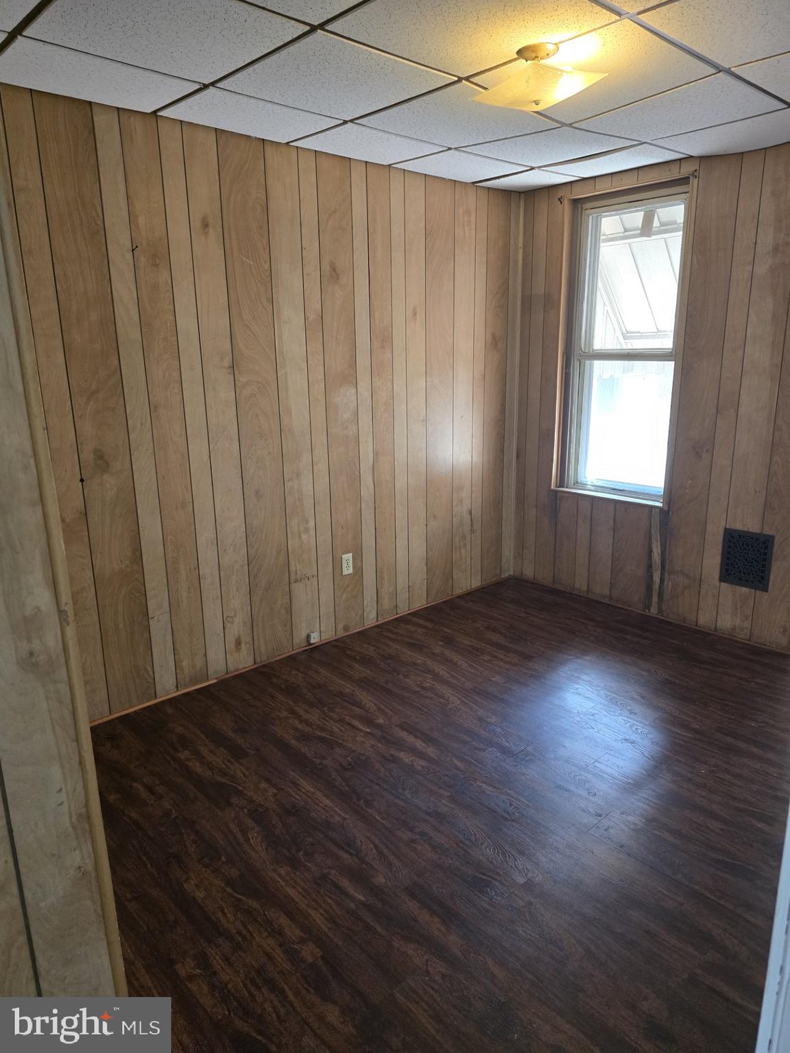 940 Mulberry Street Reading, PA 19604 - Photo 5 of 8 an empty room with wooden floor and windows with curtains