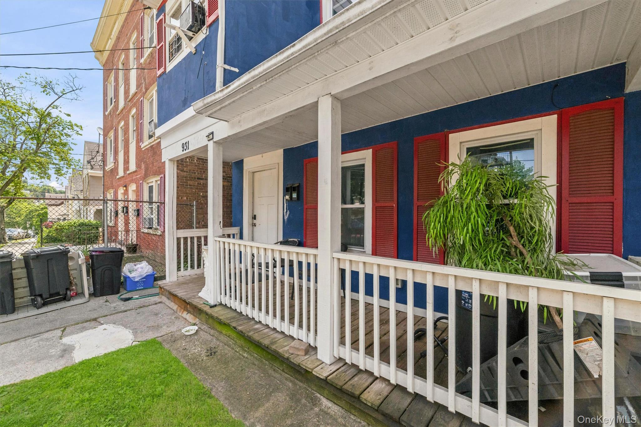 931 Diven Street Peekskill, NY 10566 - Photo 2 of 29 Covered front porch with white railing, blue exterior siding, and red louvered shutters