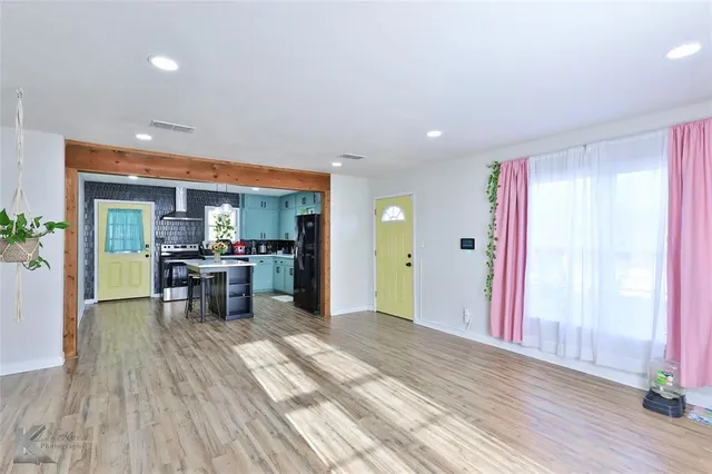 a view of a room with wooden floor and furniture