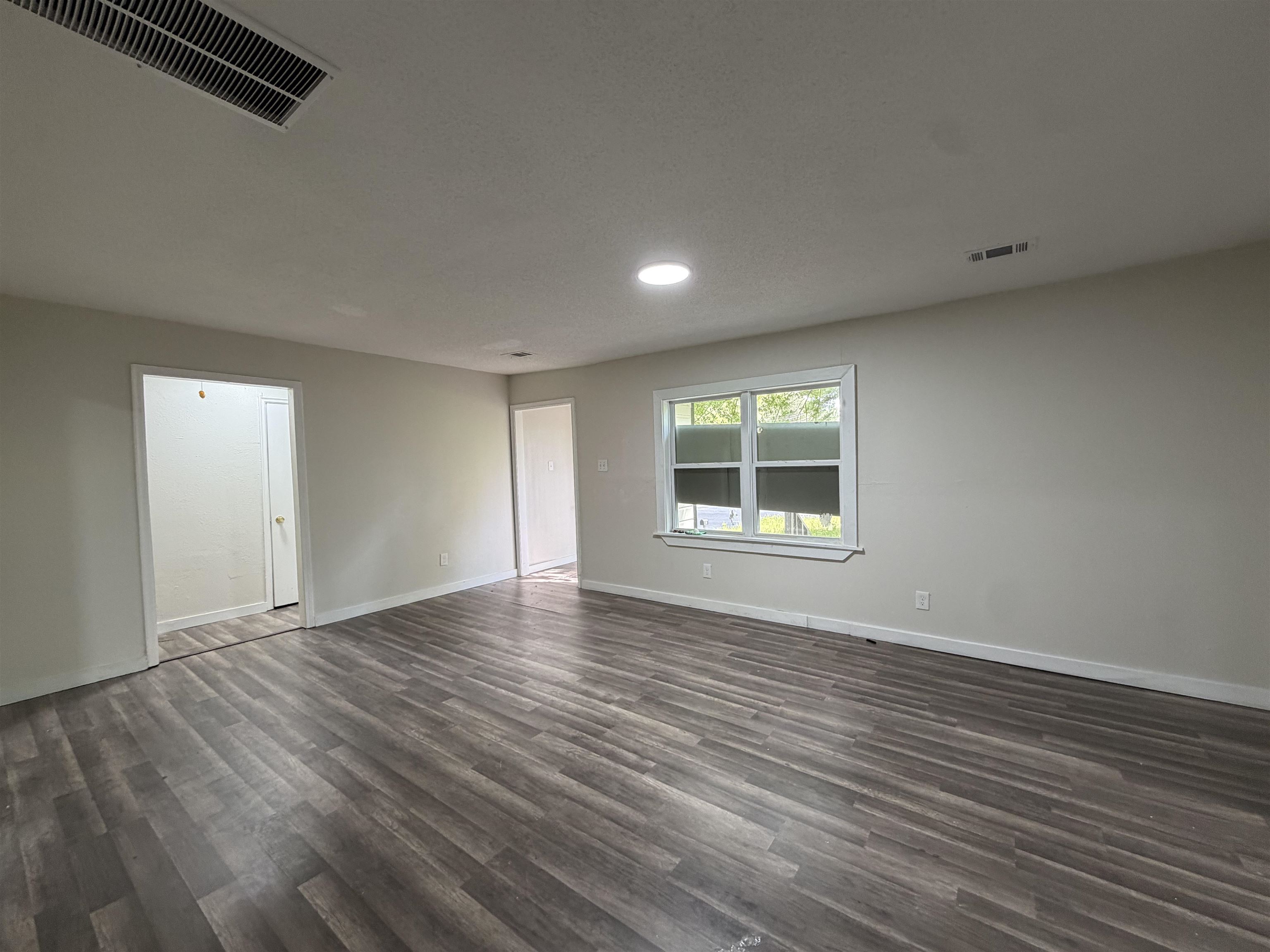 8 East Brooks Road Memphis, TN 38109 - Photo 12 of 16 a view of an empty room with wooden floor and a window