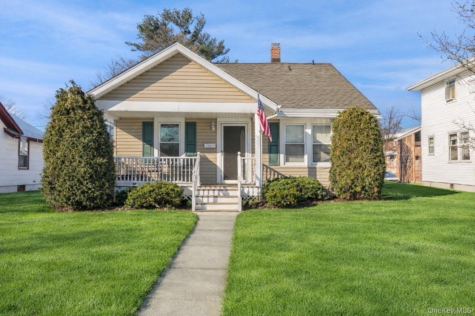 a front view of a house with a yard and potted plants