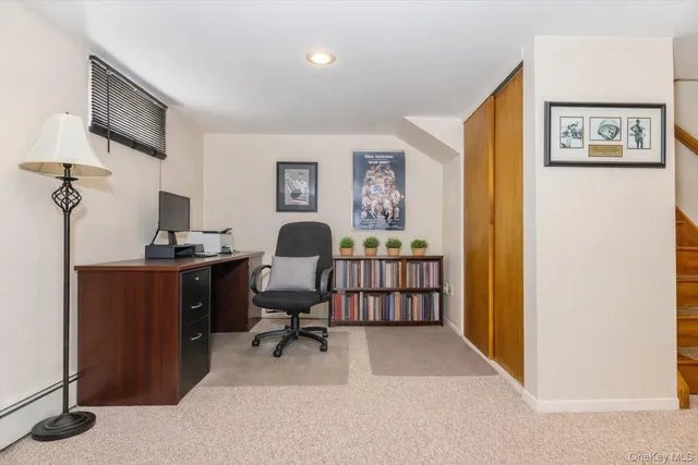 a view of a workspace with furniture and a window