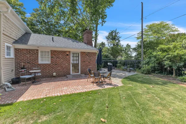a view of backyard of house with outdoor seating and green space