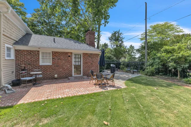 a view of backyard of house with outdoor seating and green space