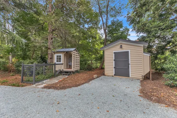a view of a house with a yard and large tree