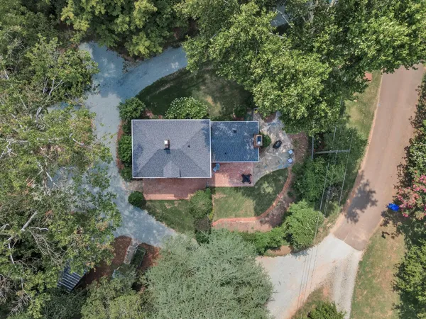 an aerial view of a house with a yard and a large tree