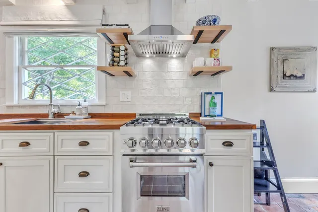 a stove top oven sitting inside of a kitchen