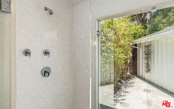 a bedroom with a large bed and a potted plant on the dresser