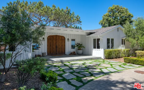 a front view of a house with potted plants