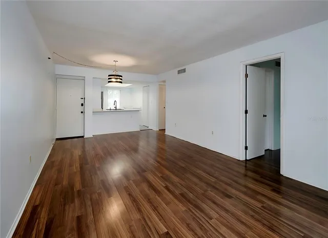 a view of empty room with wooden floor