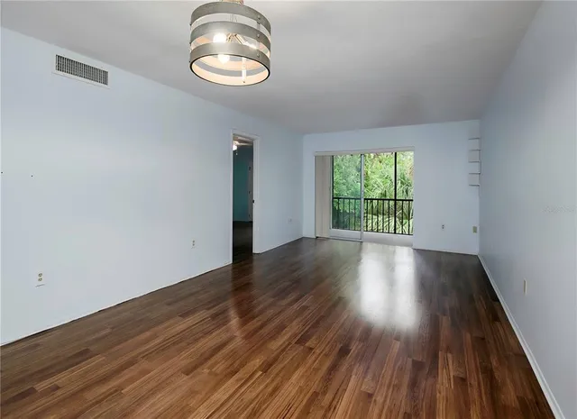 a view of a room with wooden floor and window