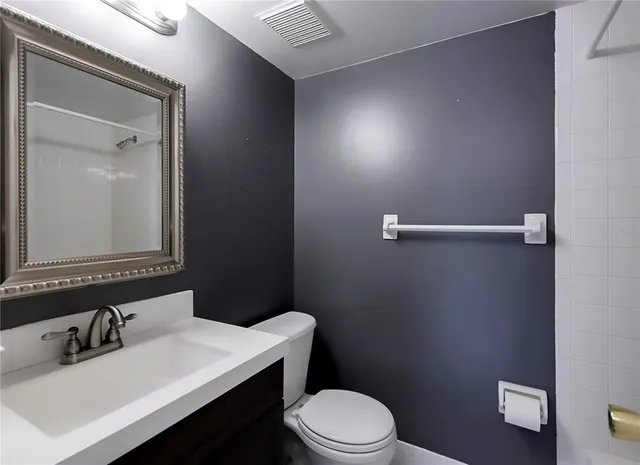 a bathroom with a sink vanity mirror and toilet