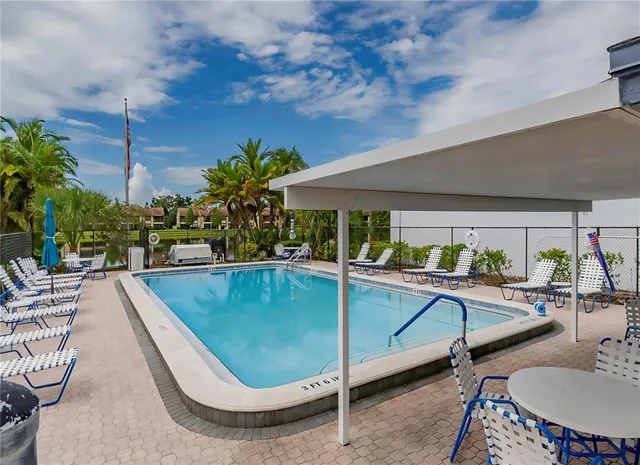 a view of a swimming pool with outdoor seating and plants