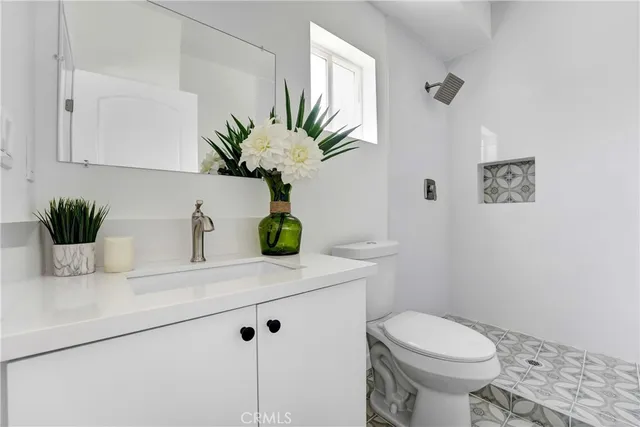 a bathroom with a sink a toilet and a mirror