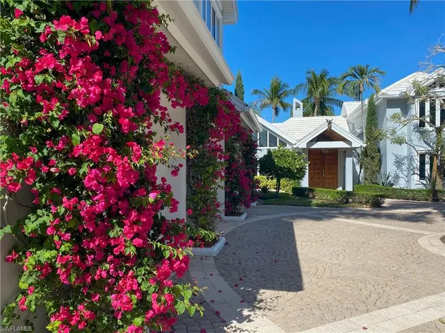 a front view of a house with a lot of flower plants