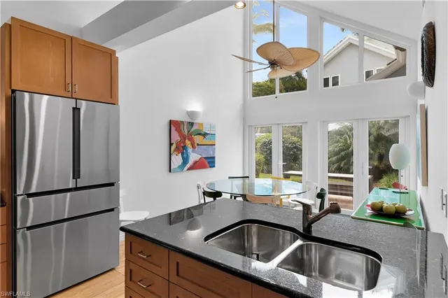 a kitchen with stainless steel appliances granite countertop a sink and a refrigerator