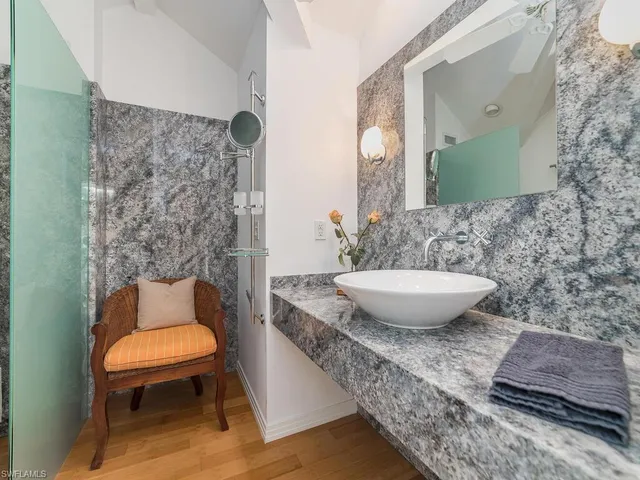 a bathroom with a granite countertop toilet a sink and a mirror