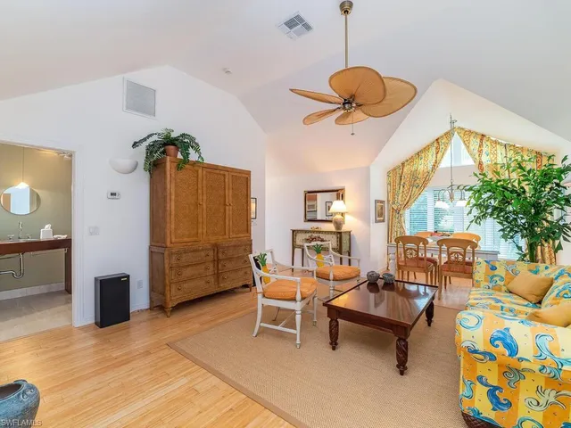 a living room with furniture a chandelier and a rug