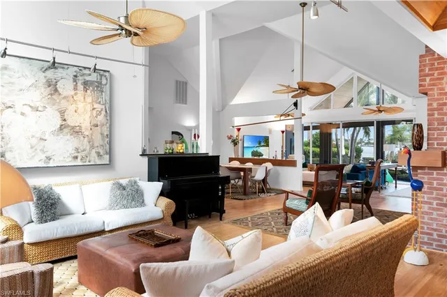 a living room with furniture a chandelier and a large window
