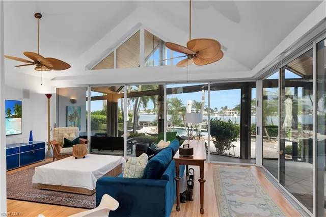 a living room with patio furniture and a floor to ceiling window