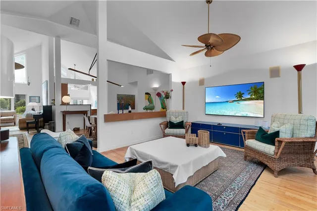 a living room with furniture kitchen view and a large window